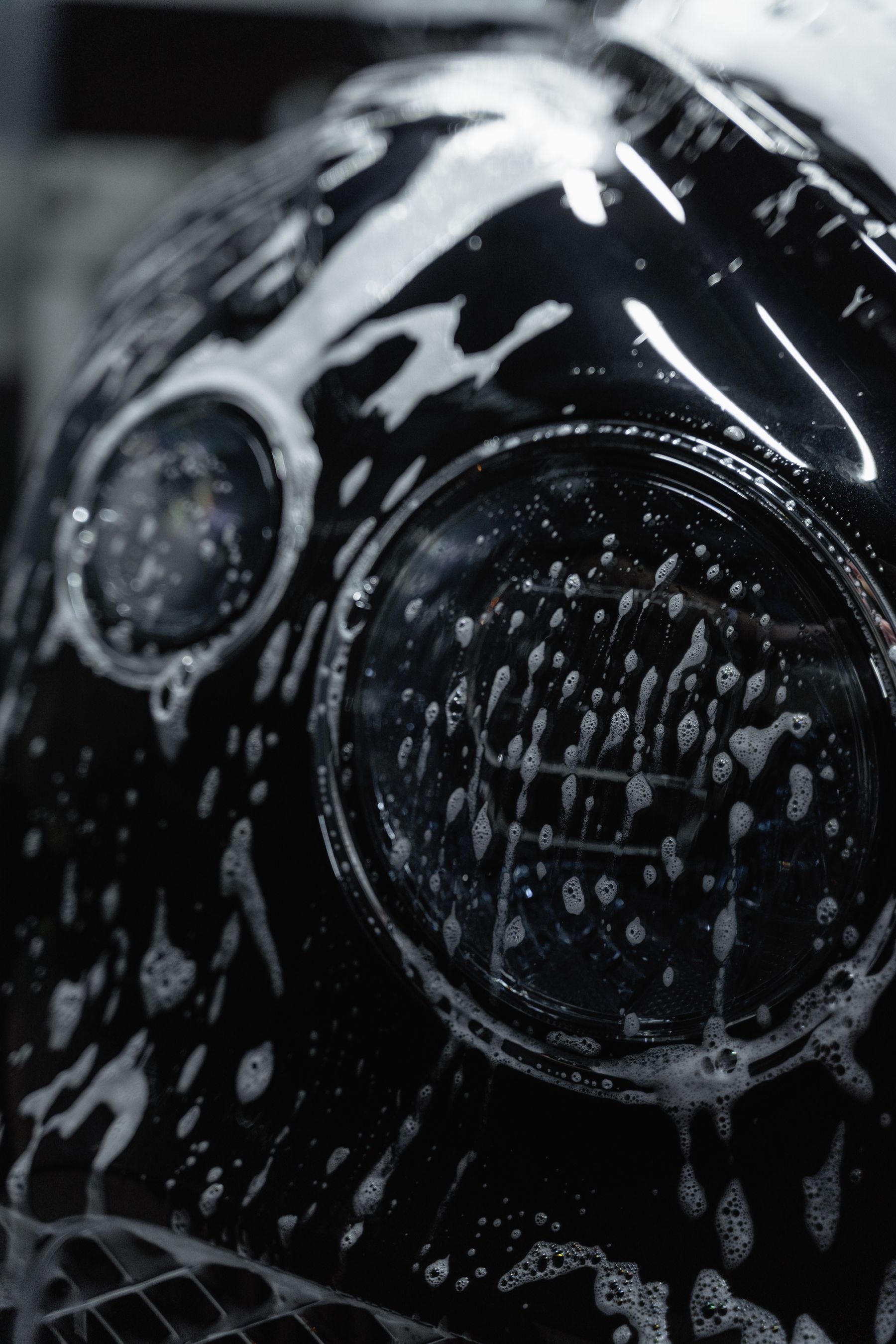 Headlight and front bodywork covered in wash foam