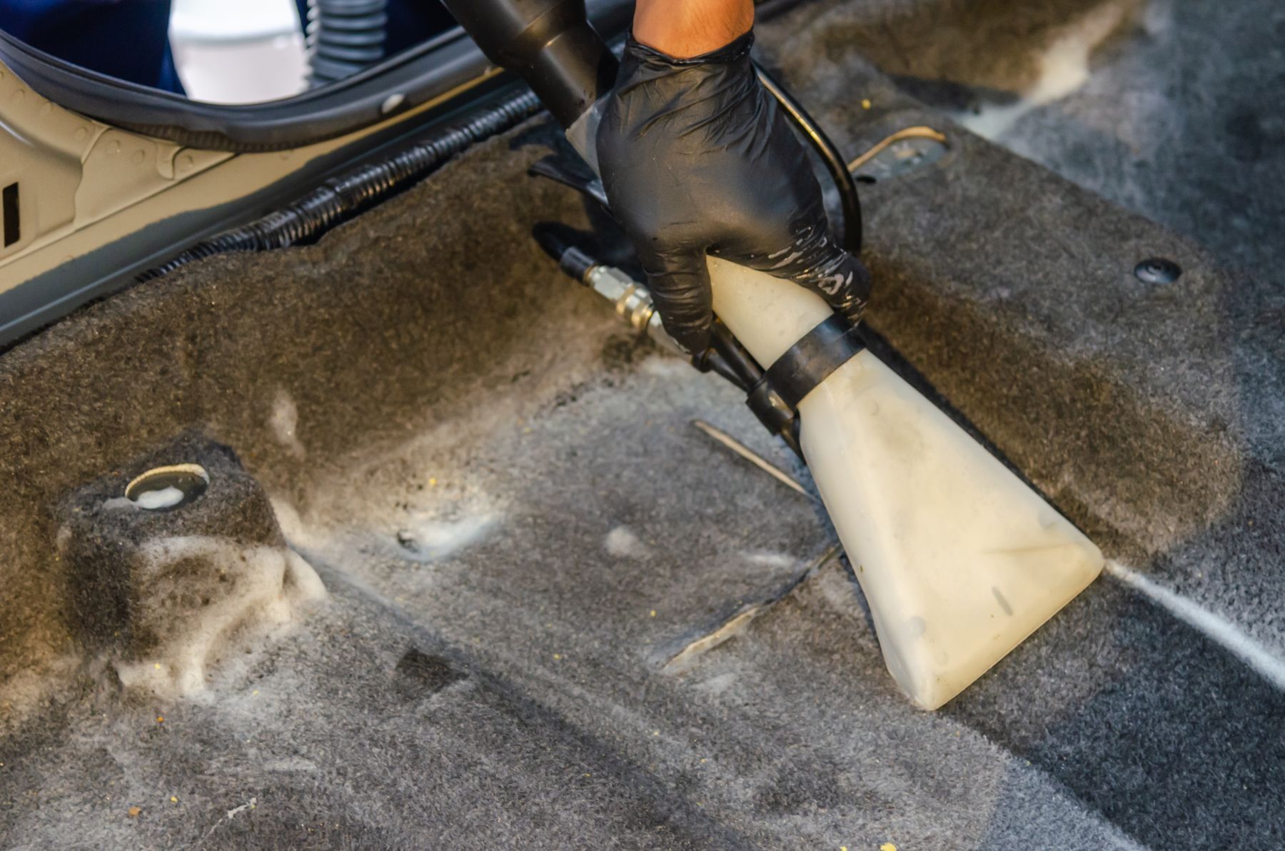 Extraction nozzle cleaning vehicle carpet
